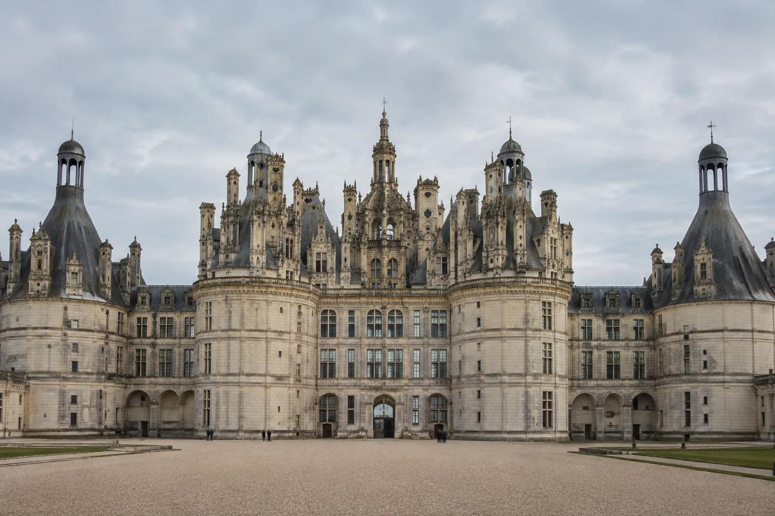 La silhouette du château de Chambord, avec ses tours, ses cheminées et ses lucarnes sous un ciel clair.
