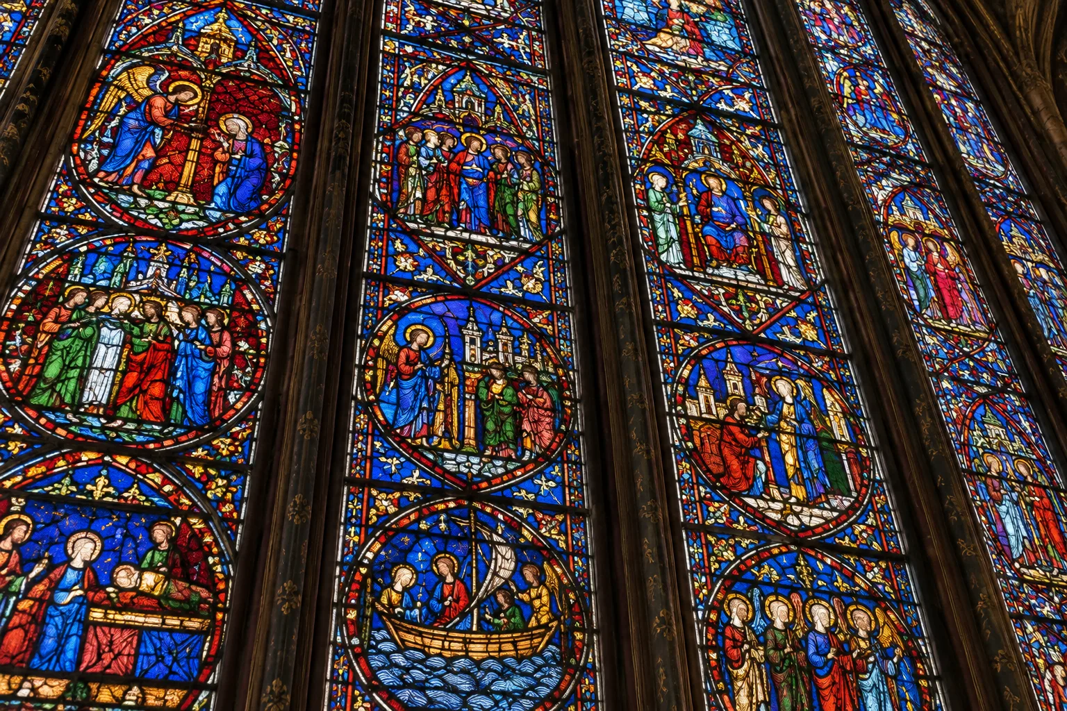 Détail des lancettes de la chapelle haute, où les scènes bibliques se composent de verres colorés.