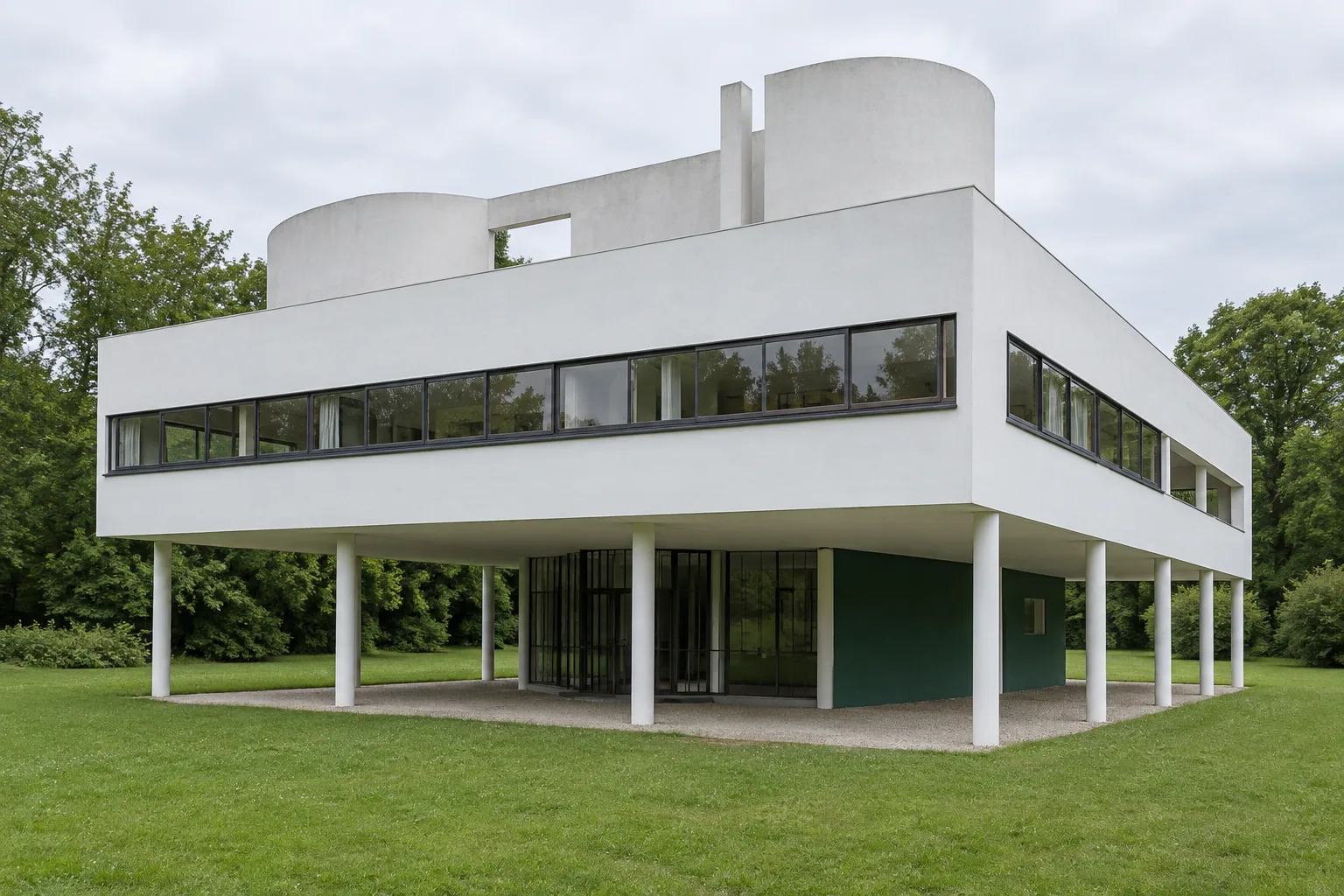 La façade blanche de la Villa Savoye, portée par des pilotis au-dessus d’une pelouse.