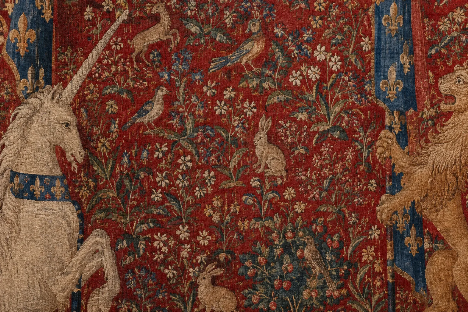 Détail d’un fond rouge millefleurs où se mêlent fleurs et petits animaux.