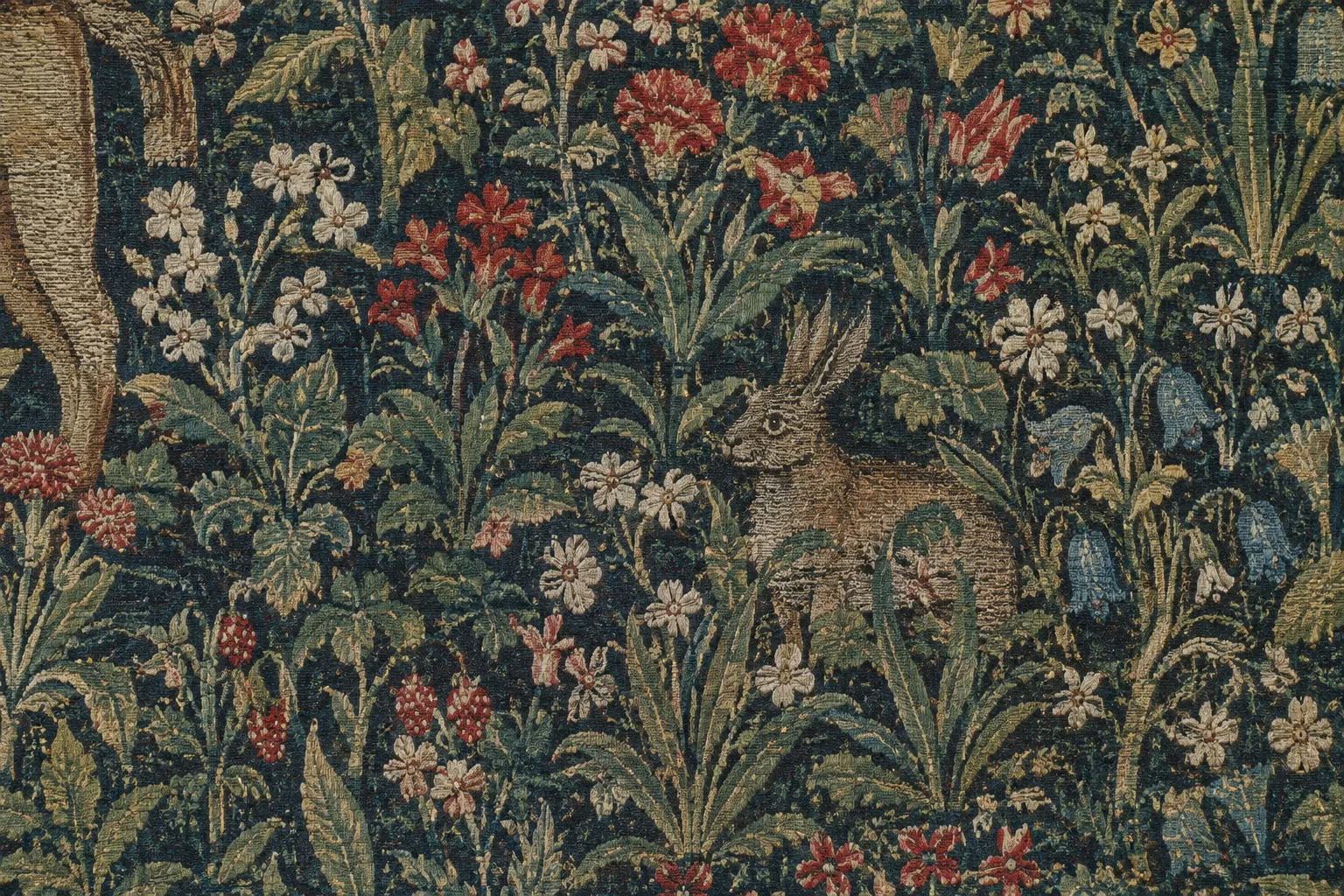 Gros plan sur des fleurs et des feuilles tissées, avec un petit animal dissimulé dans la végétation.