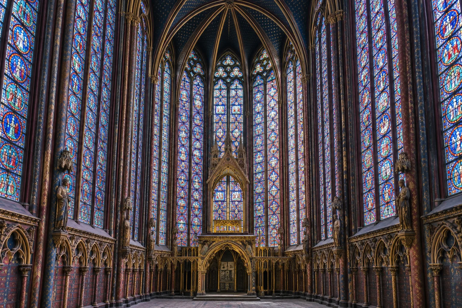 Les hautes verrières colorées de la chapelle supérieure de la Sainte-Chapelle éclairées par la lumière du jour.